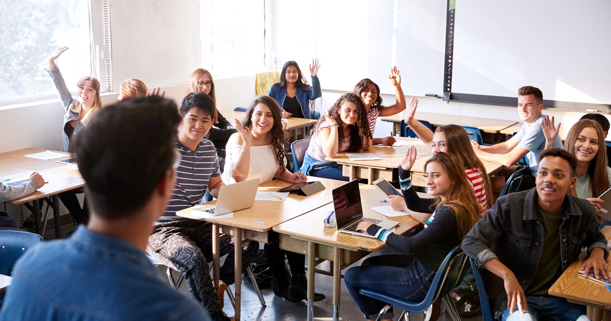 Gruppe von Jugendlichen diskutiert intensiv im Klassenzimmer über ein Thema der nachhaltigen Entwicklung