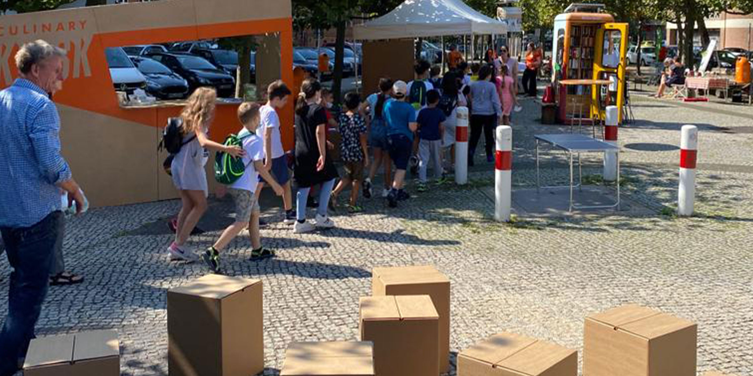 Culinary Kiosk Workshop im Freien in Berlin mit Kindern und Papphockern, Fokus auf nachhaltige Ernaehrung und Bildung.